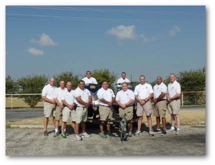 Boat Patrol Division pose next to their boat trailer